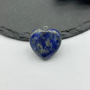 Close-up detail of natural blue lapis lazuli gemstone heart pendant with silver jump ring.
