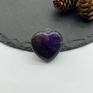Natural amethyst crystal heart pendant detail shot, gorgeous purple stone jewelry accessory.