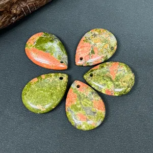 Gros plan de pendentifs goutte d'unakite naturelle, percés pour la création bijoux.