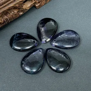 Gros plan de pendentifs gouttes en cristal violet foncé poli pour la création de bijoux.