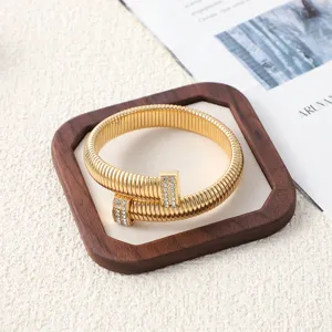 Gros plan détaillé d'un bracelet collier ras-de-cou doré à ressorts avec embouts strassés.