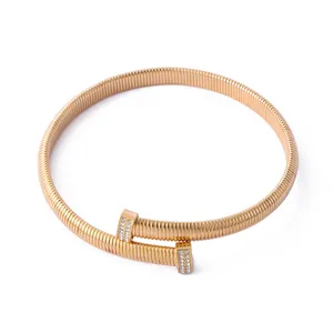 Gros plan détail de collier souple ressort or rose avec strass embouts clou luxe.