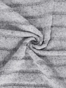Vue détaillée d'un tissu en tricot gris doux à rayures horizontales pour vêtements.