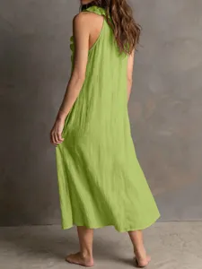 Detail view of women sleeveless linen dress featuring a ruffle halter neck and flowing midi hem.