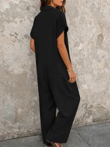 Vue détaillée d'une combinaison chemise noire unie à manches courtes, coupe ample et poches.