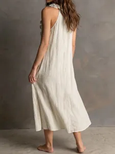 Detail view of women's sleeveless cotton linen maxi dress in cream, showing back drape.