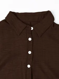 Détail de chemise marron foncé avec col, design à boutons classique et texture.