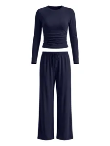Close-up details of the dark blue long sleeve crop top with waist ruching and wide leg pants.