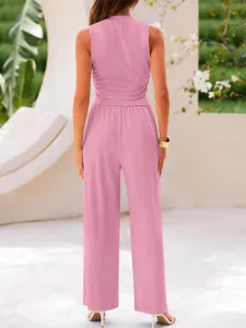 Back view detail of pink two-piece ribbed set featuring crop tank and wide-leg pants in resort setting.