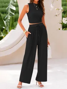 Detail shot of women's black ribbed two-piece outfit featuring a chic crop top and wide pants.