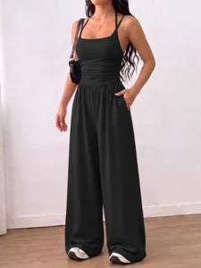 Detailed view of women's black halter jumpsuit with gathered waist and wide leg design.