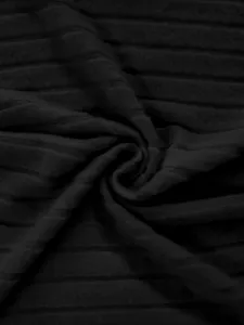 Détail de tissu côtelé noir, texture douce et de haute qualité pour tenues d'automne confortables.