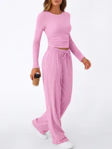 Pink loungewear set detail showing comfortable long sleeve top and relaxed wide leg pants.