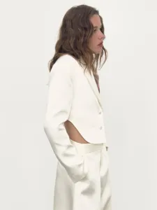 Detailansicht des weißen eleganten Blazers mit Rückenausschnitt und passender Hose.