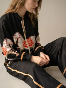 Detailed view of the vintage black two-piece set featuring ornate horse print and gold trim.