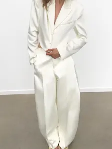 Detailansicht des weißen Satin-Blazers mit rückenfreiem Design und passenden Palazzo-Hose.