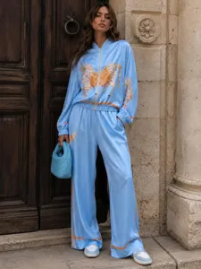 Retro blue satin two-piece tracksuit featuring horse print and chic orange piping details.