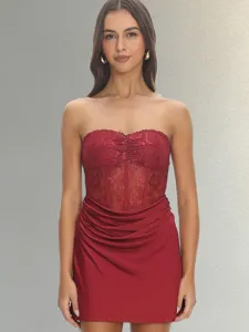 Close up of red strapless dress featuring lace corset bodice and elegant draped skirt detail.