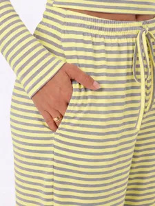Yellow and grey striped loungewear set detail showcasing pocket and soft fabric texture.