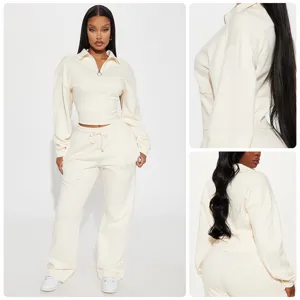Detailaufnahme des cremeweißen Sweatshirt-Sets mit halbem Reißverschluss und Hose.