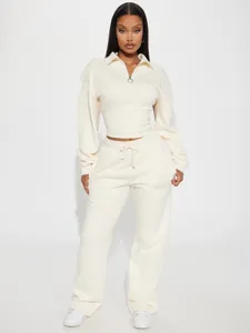 Detailansicht des beigen Sweatshirt-Sets mit halbem Reißverschluss und langen weiten Hosen.