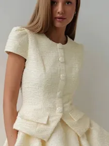 Close-up of ivory white tweed short sleeve dress, featuring round neck and peplum.