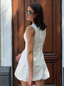 Close-up detail of the stylish white sleeveless waistcoat and bubble skirt two-piece outfit.