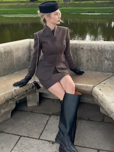 Detailansicht des eleganten Retro Kostuems mit Stehkragen und Minirock im herbstlichen Braun.