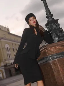 Detailed view of the French style black peplum blazer and midi skirt outfit with vintage hat.