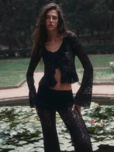 Detail shot of a black lace two-piece set featuring a cropped ruffle V-neck top and flared pants.