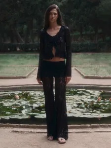 Black lace two-piece set featuring a v-neck crop top and matching long flare pants.