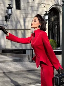 Detail view of the red peplum blazer and fitted skirt set with chic black gloves.