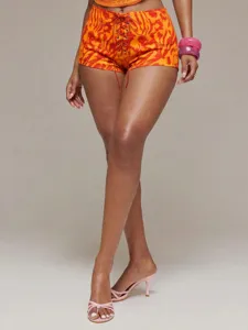 Détail en gros plan montrant l'imprimé tie-dye dégradé et le design à lacets des sexy shorts.