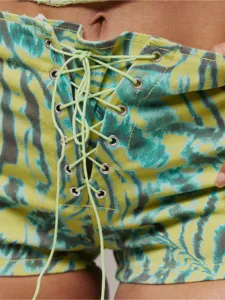 Gros plan sur les details de la taille nouee en cravate tie and dye de ces shorts.
