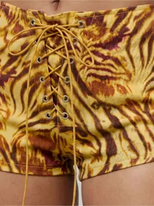 Vue en gros plan des détails de laçage frontal à œillets sur short tie-dye taille haute.