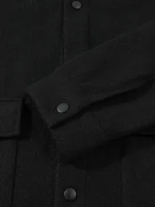 Vue détaillée d'une veste de travail noire pour homme avec boutons et texture.