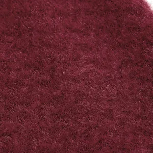 Detalle de tela de cárdigan felpa burdeos, textura suave y mullida para otoño moda.
