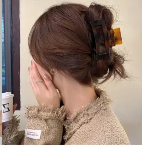 Brown tortoise shell hair claw clip for women, elegant rectangular acrylic hair catch pin.