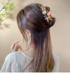 Korean crystal hair claw detail, featuring charming floral rhinestones for elegant styling.