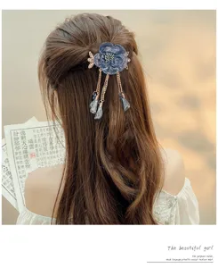Detail shot of a vintage blue flower tassel hair clip worn on long hair, elegant back view.