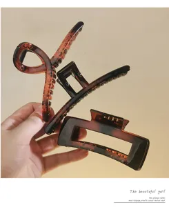 Close-up detail of assorted brown and black hair claw clips showcasing geometric shapes.