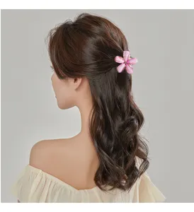 Detailansicht einer rosa Blumenform Haarklammer getragen im Haar für tägliches Styling.