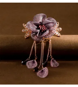 Vintage purple fabric flower hair clip detail, retro rose gold tassel design with crystals.