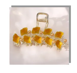 Gouden metalen ginkgo blad haarklem met gele emaille en parels voor stijlvolle haarstijlen