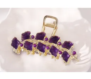 Gedetailleerde close-up van de luxe paarse ginkgobladeren metalen haarklem met parels.