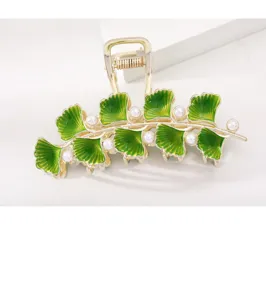 Gedetailleerd overzicht van de vintage ginkgoblad metalen haarklem met groen email en parels.
