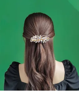 Detailed view of the elegant pearl and rhinestone hair clip worn on long hair. Perfect for styling.