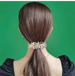 Detailed view of the elegant pearl rhinestone hair clip worn on the back of hair.