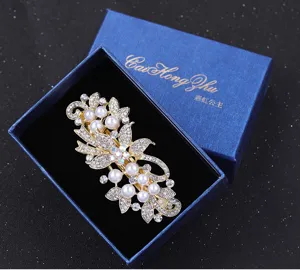 Close up detail of elegant rhinestone pearl hair clip spring barrette in luxury blue box.