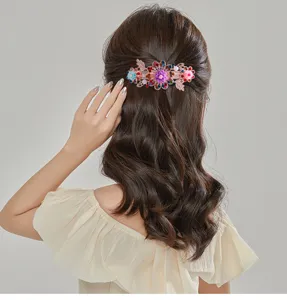 Detail view of sparkling crystal flower hair clip worn on back half-tied hair style closeup